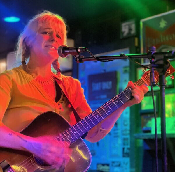 Leah singing and playing guitar