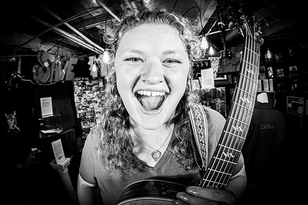 Madigan Linnane holding a guitar with a big smile